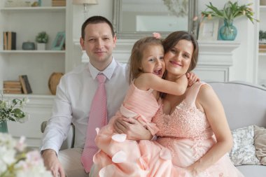 Mutlu aile sarılma ve gülümseyerek. Anne, Baba, çocuk kızı evde