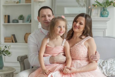 Güzel kızı evde mutlu aile portresi. Güzel aile, olumlu ifadeler. Sevgi dolu anne ve baba ile çocuk
