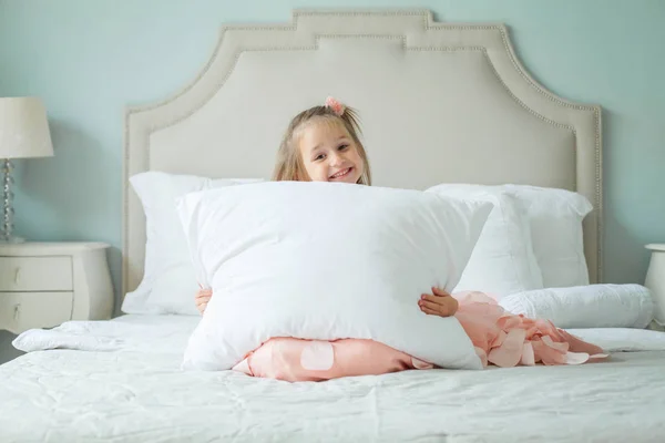 白い枕自宅で幸せな子供女の子 — ストック写真