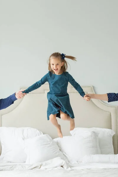 Happy child girl jumping on the bed and having fun!