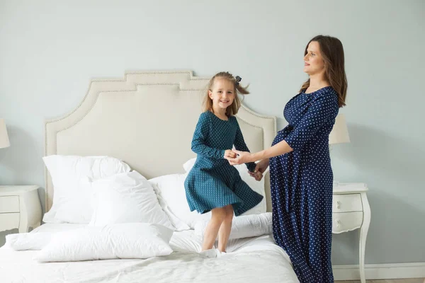 Glückliche Mutter Und Kleine Tochter Springen Auf Dem Bett — Stockfoto