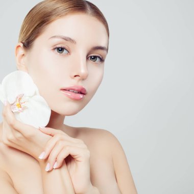 Güzel kadın sağlıklı cilt ve çiçek beyaz arka plan, spa Güzellik, kozmetik, yüz tedavi ve sağlık kavramı ile 