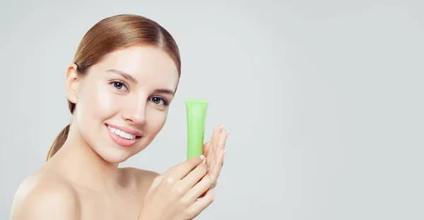 Jonge Lachende Vrouw Met Moisturizer Crème Tube Een Witte Achtergrond — Stockfoto