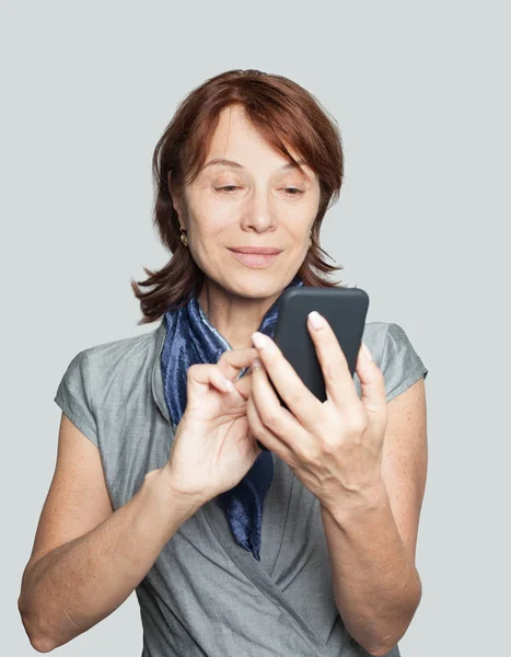 Lachende Volwassen Vrouwtje Met Smartphone — Stockfoto