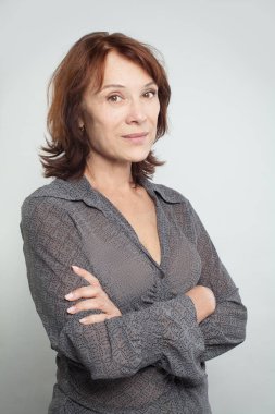 Çapraz kolları olan orta yetişkin kadın portresi