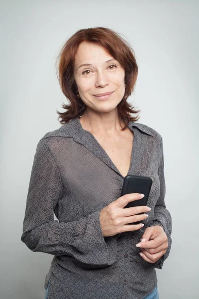 携帯電話を持つ幸せな成熟したビジネス女性 — ストック写真