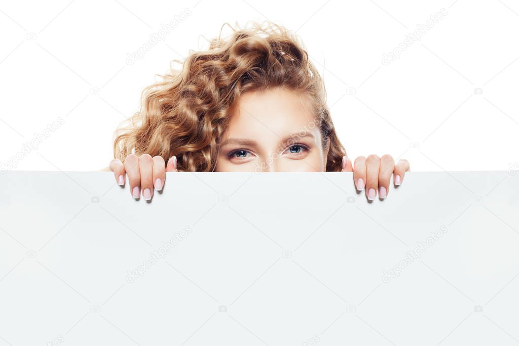 Cheerful young woman looking out white empty blank paper board isolated on white background