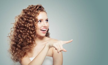 İşaret çıktıktan genç kadın. Uzun kıvırcık saçlı sevimli kız öğrenci. Olumlu duygu. Etkileyici yüz ifadeleri