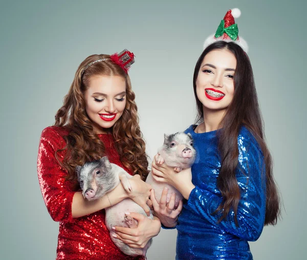 美丽的圣诞妇女在闪闪发光的礼服举行小猪 圣诞节和新年派对概念 — 图库照片