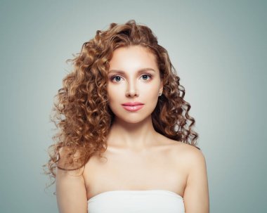 Genç kadın yüzü. Güzel bir kadınla uzun sağlıklı dalgalı saç modeli gri arka plan üzerinde