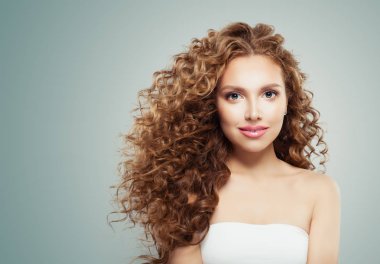 Genç güzel kadın yüzü. Gri arka plan üzerinde uzun sağlıklı saç modeli ile güzel kadın