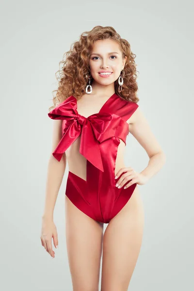 白い背景の赤い絹のような弓でファッショナブルな水着でゴージャスな女性 — ストック写真