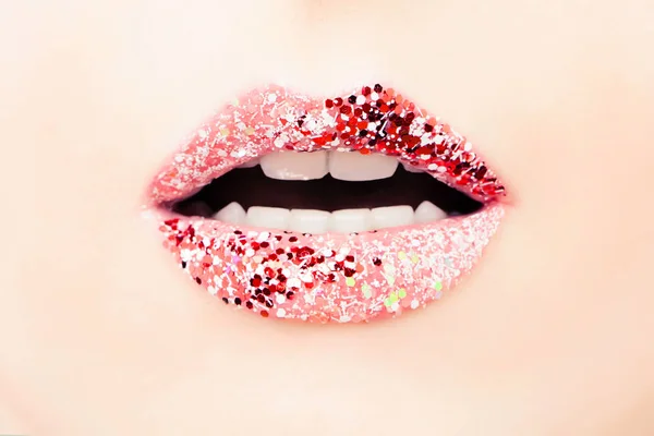 Beautiful woman lips with bright glitter lipstick, makeup and beauty background