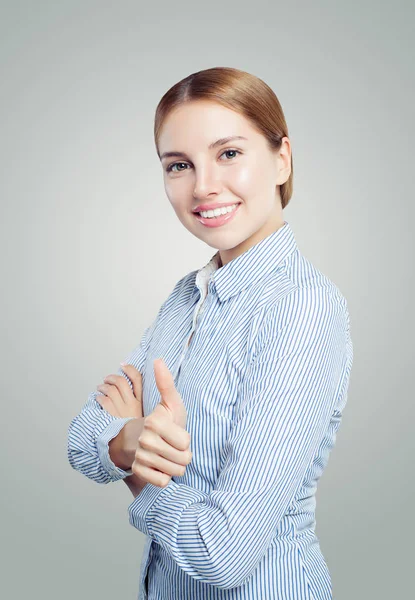 愉快的年轻女子在白色背景上展示拇指 富有表现力的面部表情 — 图库照片