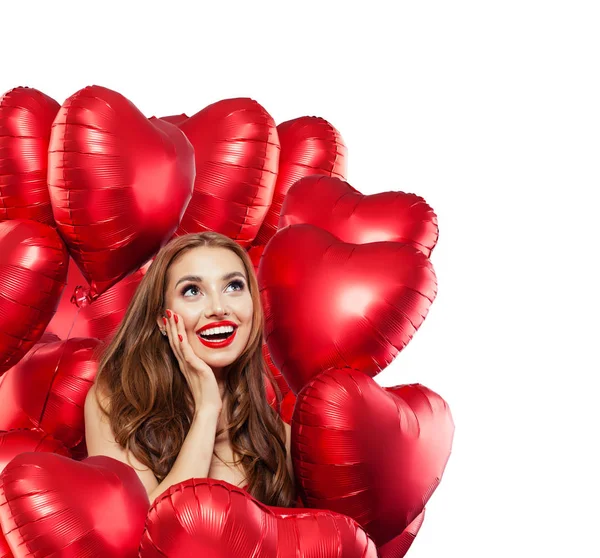 Happy surprised woman with red balloons isolated on white background. Surprised girl with red lips makeup smiling and looking up. Surprise, gifts and Valentine's day concept isolated over white