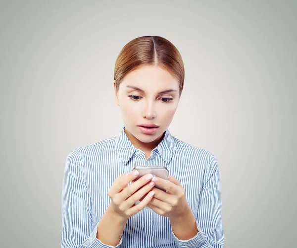 携帯電話にショックを受けた女性は スマート フォンで女の子のテキスト メッセージ — ストック写真