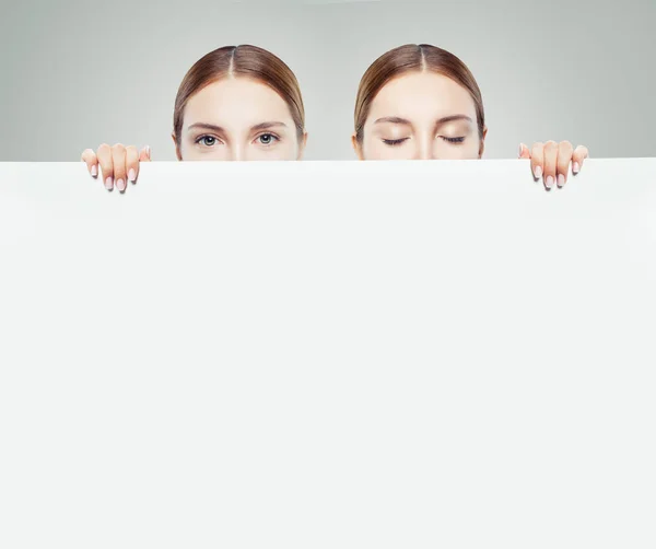 Two Young Women Looking Showing White Empty Paper Card Background — Stock Photo, Image