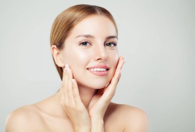 Güzel kadın kameraya bakıyor. Sağlıklı açık cilt, doğal makyaj ve beyaz arka plan üzerinde doğal kaşlar portre ile güzel yüz