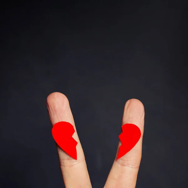 Couple fingers and red broken heart on blackboard background