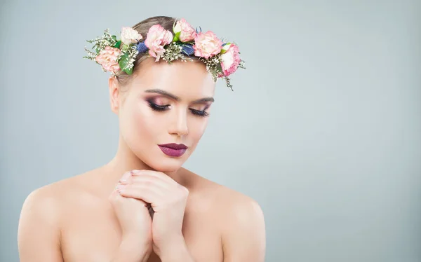 Schöne Frau mit Frühlingsrosenblüten auf dem Kopf. — Stockfoto