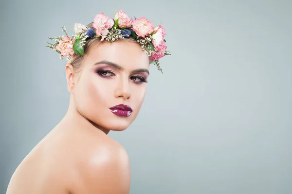 Hermosa mujer con maquillaje colorido en corona de flores — Foto de Stock