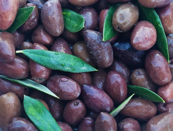 Органические оливки фон. Каламата оливки с зелеными листьями — стоковое фото