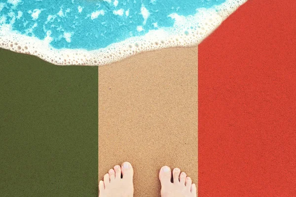 Fötterna på den soliga sand stranden med flagg Italien. Vy uppifrån — Stockfoto