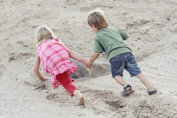 Barn leker tillsammans och övervinna svårigheter. Hjälp koncept — Stockfoto