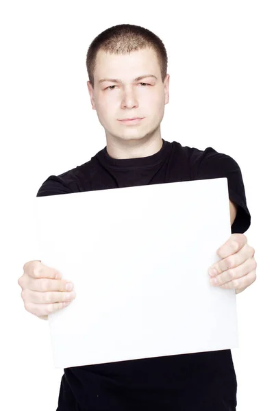 Jeune homme tenant une feuille blanche vide sur fond blanc isolé — Photo
