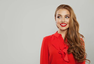 Güzel mutlu model gülümseyen ve beyaz bir kenara bakıyor