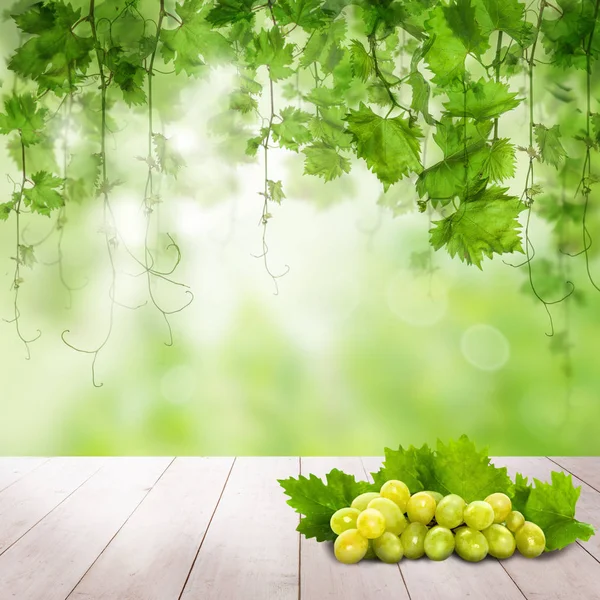Uvas sobre mesa de madera clara. Fondo verde soleado — Foto de Stock