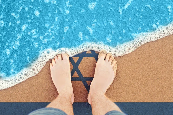 Τα πόδια στην ηλιόλουστη αμμώδη παραλία με σημαία Ισραήλ. Κορυφαία προβολή στο surf — Φωτογραφία Αρχείου
