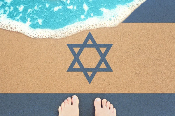 Stopy na słonecznej piaszczystej plaży z flagą Izraela. — Zdjęcie stockowe