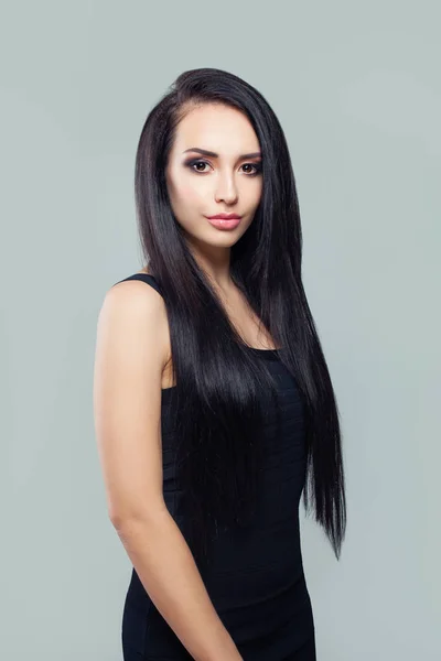 Mujer elegante con cabello largo y sano y maquillaje con vestido negro —  Fotos de Stock