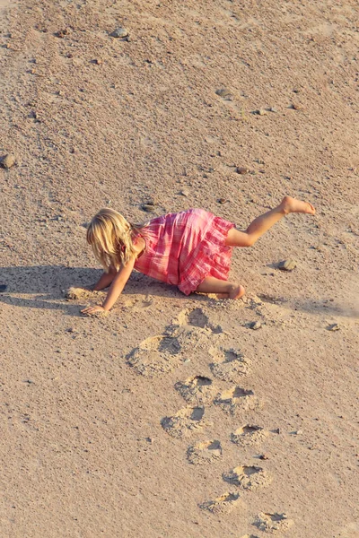 komik kız kum dağından kırmızı elbise düşüyor