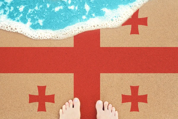 Bayrağı Gürcistan ile güneşli kumlu plajda ayaklar. — Stok fotoğraf