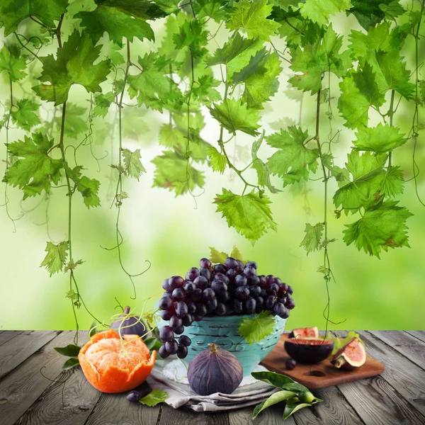 Fruit op houten tafel in groene zonlicht tuin. Eco groene druiven — Stockfoto