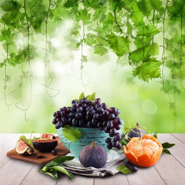 Фруктовий солодкий десерт на дерев'яному столі з зеленим виноградним листям — стокове фото