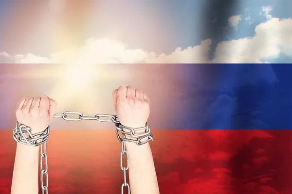 Dos manos encadenaron una cadena de metal en el fondo de la bandera de Rusia —  Fotos de Stock