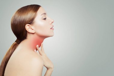 Genç kadın bir boğaz ile. Kadın ellerini boynuna koyar.