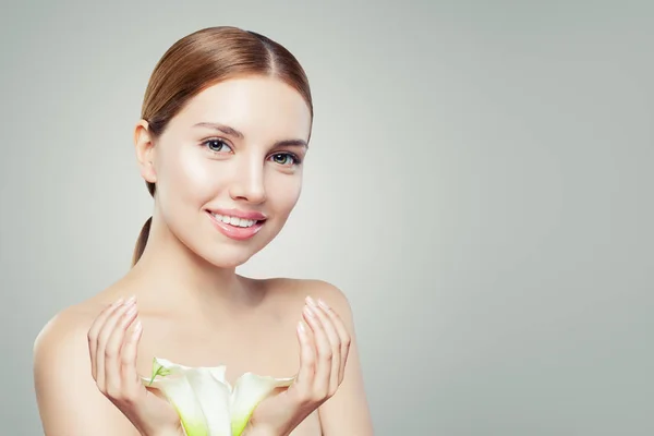 Mooie vrouw gezicht. Gezond model met heldere huid en bloemen. — Stockfoto