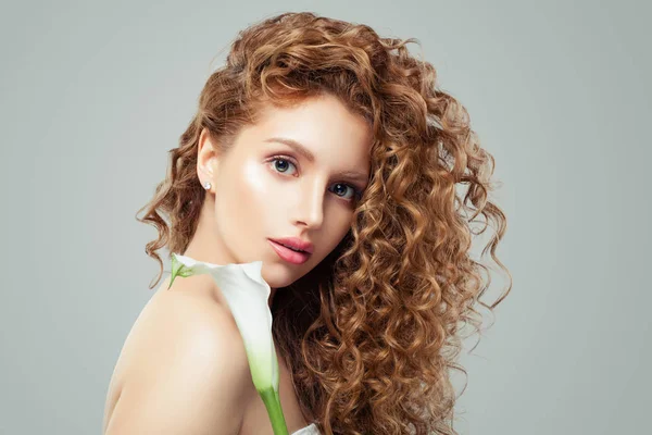 Mulher bonita com cabelo castanho encaracolado e flor de lírio — Fotografia de Stock