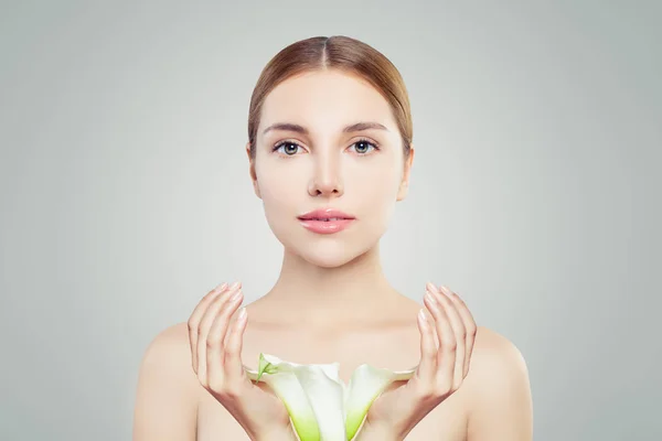 Young woman with clear skin and flowers. Skincare and facial treatment concept — Stock Photo, Image