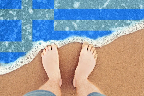 Pés na praia de areia com bandeira da Grécia. Vista superior sobre o mar Onda — Fotografia de Stock