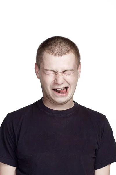 Retrato de un joven. Expresión facial. mueca con lengua —  Fotos de Stock