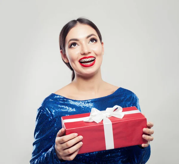 Smiling woman in braces with gift — Stock Photo, Image
