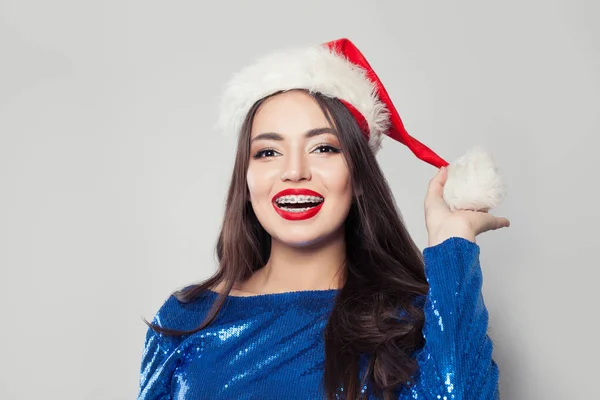 Happy young woman in braces wearing Santa hat and smiling — Stock Photo, Image