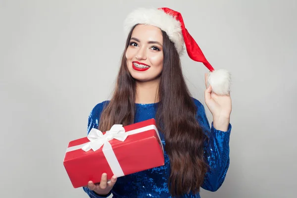 Lycklig kvinna i hängslen leende och hålla julklapp. — Stockfoto