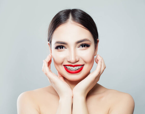 Cheerful young woman with braces on teeth laughing 