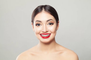 Beyaz arka planda gülümseyen parantez içinde çekici esmer kadın